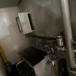 Cabine de lavage équipée d’un convoyeur pour positionner les chariots dans la cabine. 2 chariots inox sur roulettes pour planches d’affinage